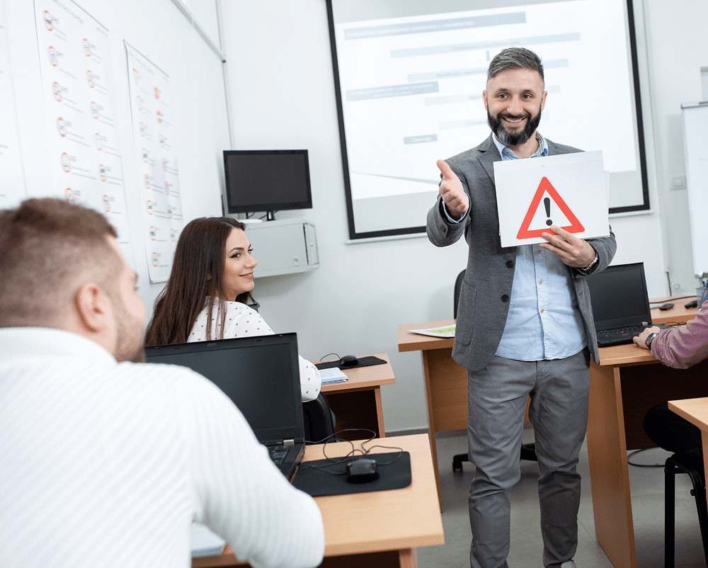 Teacher holding caution sign during lecture