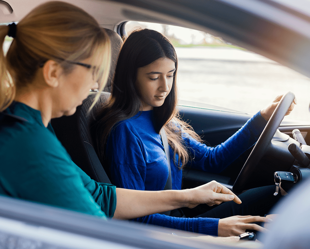 Woman teaching teenager to drive