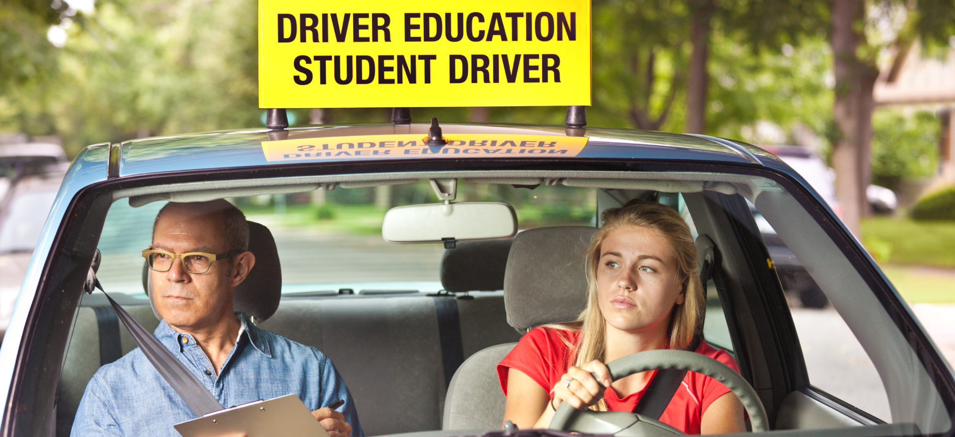 Young girl taking lessons for driving on the road in Auckland, New Zealand.